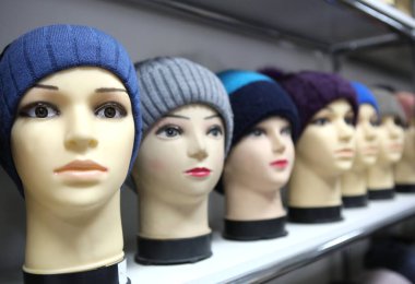 Örgü şapka ve eşarplı manken kafalar. Şapkalı ve eşarplı kadın mankenler yaklaşın. Yünlü örgü kepler ve eşarplar. Kadın başlıkları.