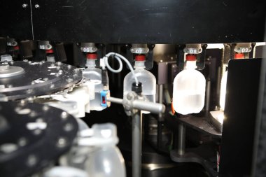 İlaç endüstrisi, ilaç hapları ilaç fabrikasındaki üretim hattı makinesinin plastik şişesini dolduruyor. Ampul doldurma ve mühürleme makinesi, ilaç ekipmanları.