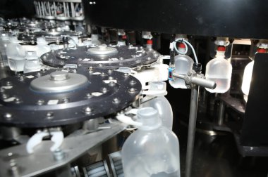 İlaç endüstrisi, ilaç hapları ilaç fabrikasındaki üretim hattı makinesinin plastik şişesini dolduruyor. Ampul doldurma ve mühürleme makinesi, ilaç ekipmanları.