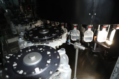 İlaç endüstrisi, ilaç hapları ilaç fabrikasındaki üretim hattı makinesinin plastik şişesini dolduruyor. Ampul doldurma ve mühürleme makinesi, ilaç ekipmanları.