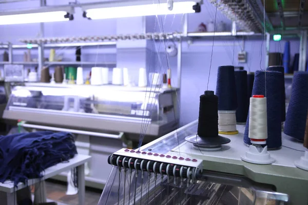Różowe szpule nici na tle warsztatu szycia. Przemysł odzieżowy. Maszyna dla przemysłu tekstylnego. Wytwarzanie odzieży. Nowa fabryka krawiecka. — Zdjęcie stockowe