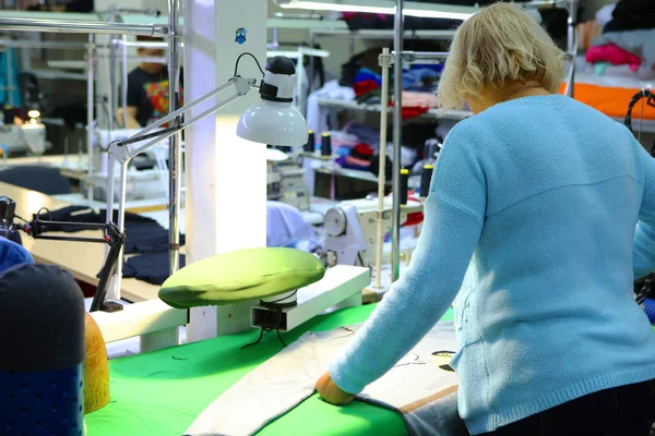 縫製工場を背景に糸のピンクのスプール。衣類産業。繊維産業のための機械。衣料品の製造。仕立てのための新工場. — ストック写真