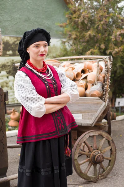 Menina bonita em vestido nacional. Segurando um pote antigo em suas mãos. Roupas antigas do final do século XIX. Belo vestido e saia em uma mulher. O conceito de vida rural, tradições nacionais — Fotografia de Stock