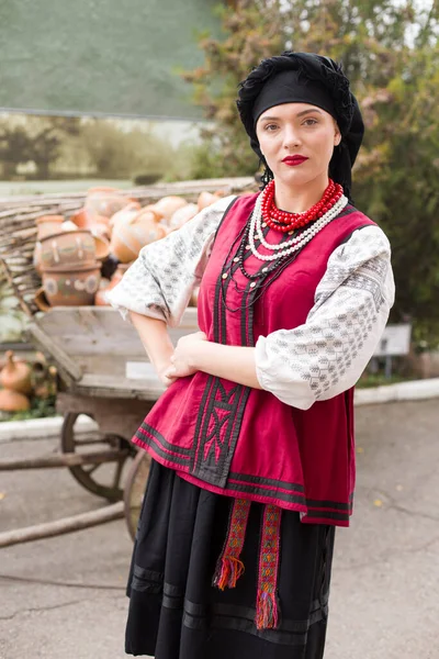 Beautiful girl in national dress. Holding an ancient pot in his hands. Antique clothing of the late 19th century. Beautiful dress and skirt on a woman. The concept of rural life, national traditions — Stock Photo, Image