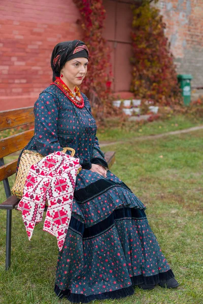Nő egy kosárban retro ruhákban a 19. században. A 19. század végi antik ruhák. Gyönyörű ruha és szoknya egy nőn. Gyöngyök és dekoráció egy lányon. Ősi hely. Hagyomány és — Stock Fotó