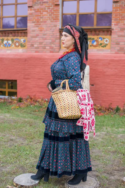 Kobieta z koszem w retro ubrania z 19 wieku. Starożytna odzież z końca XIX wieku. Piękna sukienka i spódnica na kobiecie. Koraliki i dekoracja na dziewczynie. Starożytne miejsce. Tradycja i — Zdjęcie stockowe