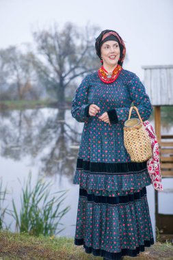 19. yüzyılın eski kıyafetleri içinde sepeti olan bir kadın. 19. yüzyılın sonlarına ait antika kıyafetler. Bir kadında güzel elbise ve etek. Bir kızda boncuk ve süs. Eski bir yer. Gelenek ve