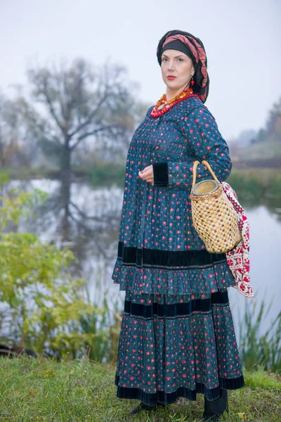 一个穿着19世纪复古服装的女人。19世纪末的古董服装。女人穿上漂亮的衣服和裙子.女孩身上的珠子和装饰。古老的地方传统和宗教 — 图库照片