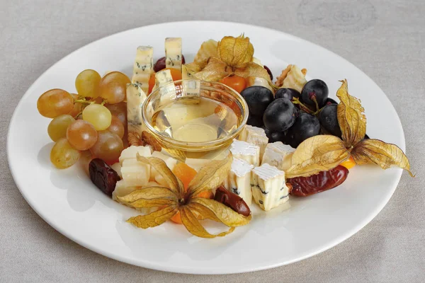 Cheese plate with honey and grapes — Stock Photo, Image