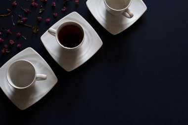 Koyu mavi masada üstten görünüm beyaz fincan çay. Soyut kahvaltı kompozisyon arka planı için