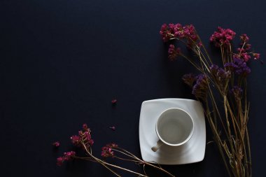 Beyaz Kupası ve koyu mavi masaya çiçek soyut kahvaltı kompozisyonu.