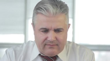 Yaşlı işadamı sorunu çözerken yüzümde bir gülümseme ile sandalyesine geri eğilir