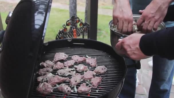 Carne de porco shish kebab sobre a natureza na grelha. Os homens colocam a carne na grelha. — Vídeo de Stock