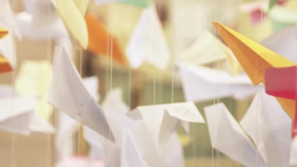 Muchos aviones de papel colgando de cuerdas. Decoración creativa — Vídeos de Stock