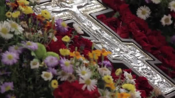 La cruz ortodoxa yace sobre el altar en flores — Vídeos de Stock