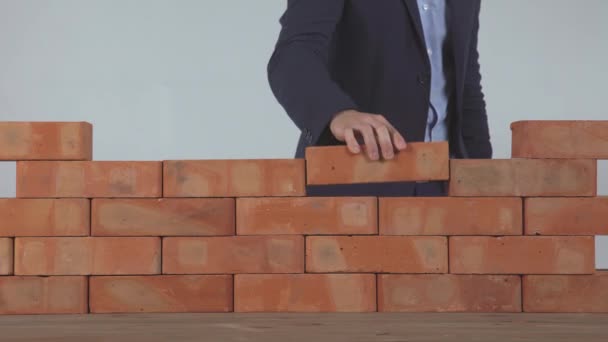 Mão coloca o tijolo na parede — Vídeo de Stock