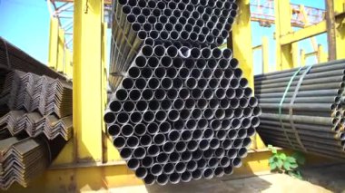 Metal bir depodaki yuvarlak metal boru bir sokak deposunun rafında duruyor. Kamera hareket halinde