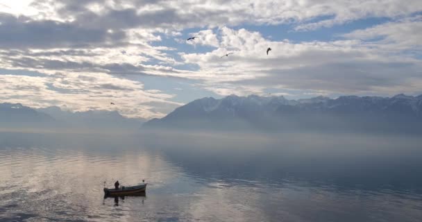 Pessoa em silhueta de canoa deriva na superfície calma da água do lago — Vídeo de Stock