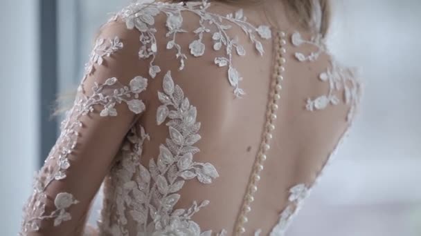 Brud tillbaka i bröllopsklänning med glittrande broderi nära — Stockvideo