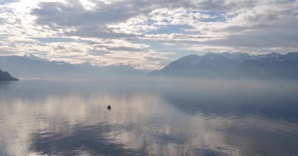 शांत झील पानी पहाड़ों के खिलाफ सफेद बादल के साथ आकाश को दर्शाता है — स्टॉक वीडियो