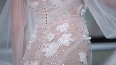 Kıvırcık saçlı kız şeffaf gelinlik giymiş.