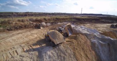 Büyük taş ocağı damperli kamyonlar kumu hava manzarasına boşaltıyorlar.