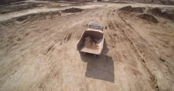Camion à benne basculante carrière conduit le long de la route terrestre brune aérienne — Video