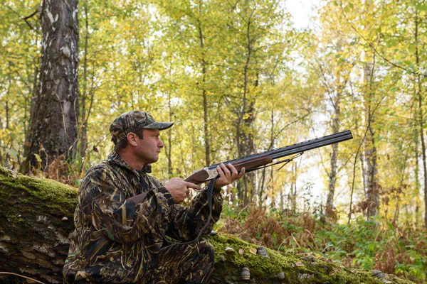 Hunter con un arma en el bosque de otoño — Foto de Stock