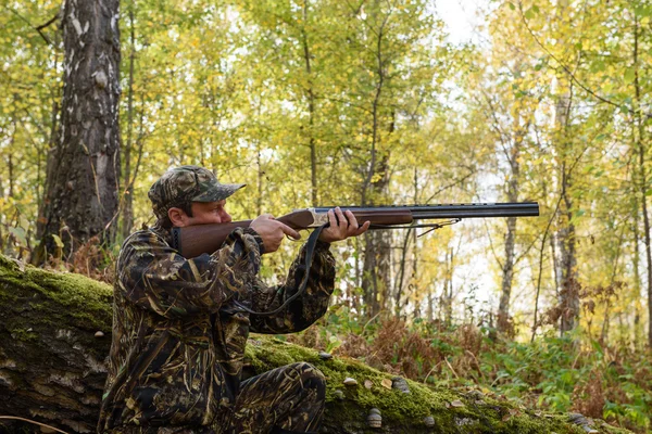 Hunter con un arma en el bosque de otoño — Foto de Stock