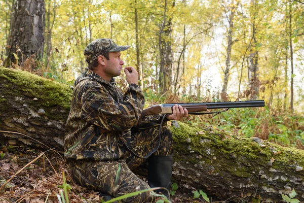 Hunter con un arma en el bosque de otoño — Foto de Stock