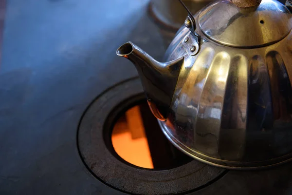 Wood burning stove. Tea is on the stove plate. — Stock Photo, Image