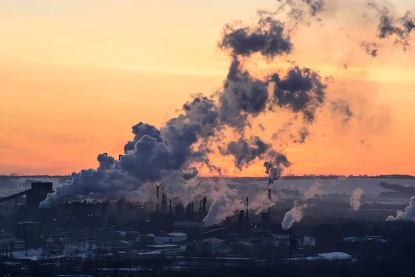 Os tubos da planta jogam fora a fumaça tóxica no por do sol . — Fotografia de Stock