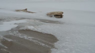 Kar fırtınası, deniz kıyısı, güçlü rüzgar kar tanelerini taşır.