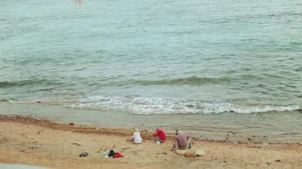 Dědeček s vnoučaty hrající si na pláži u moře, zpomalený film, 4k