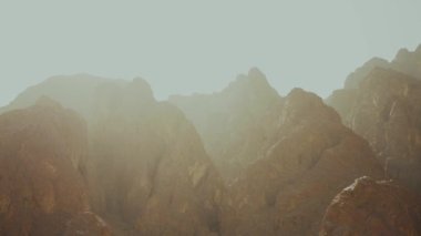 Çöl kanyonu arka planı. Bir grup turist sıcak çölde kaya kanyonu boyunca yürüyorlar, Mısır, Sina, yavaş çekim, 4k