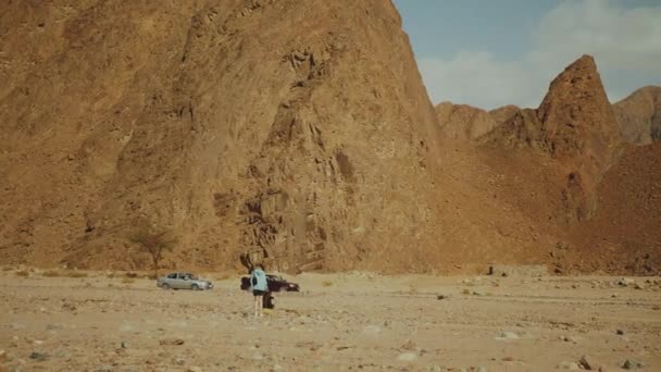 Eine Touristengruppe wandert entlang der Felsschlucht in der heißen Wüste. Wüstenfelsen Hintergrund, Ägypten, Sinai, Zeitlupe, 4k — Stockvideo