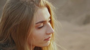 Gitar çalan ve çöl manzaralarında şarkı söyleyen kadın, çöl arkaplanı, ağır çekim, 4k