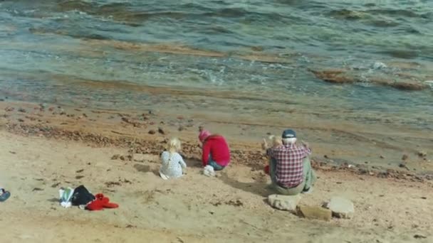 Abuelo con nietos jugando en la playa junto al mar, cámara lenta, 4k — Vídeos de Stock