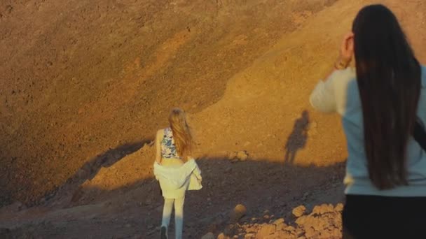Grupo de passeio turístico ao longo do desfiladeiro de rocha no deserto quente, os turistas tirar fotos e se divertir. Deserto montanhas fundo, Egito, Sinai, câmera lenta, 4k — Vídeo de Stock