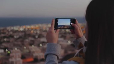 Akşamları kadın akıllı telefondan denizin fotoğrafını çeker. Kadın dağın tepesinde durur ve Horizon 'a bakar, ağır çekimde, 4k