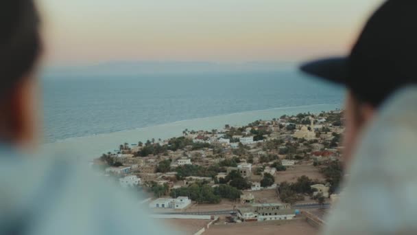 Grupo de amigos relaxando no topo de uma montanha ao pôr do sol e desfrutando de vista mar - amizade, juventude, câmera lenta, 4k — Vídeo de Stock