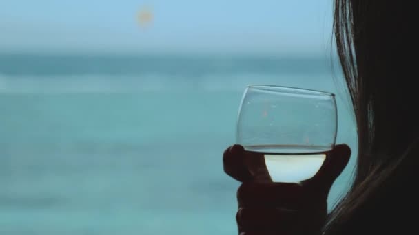 Femme boire du vin et regarder comment les gens cerf-volant surf dans une belle eau claire à Dahab Egypte. Explorer la mer bleue avec des montagnes en arrière-plan et les gens kite surf, ralenti, 4k — Video