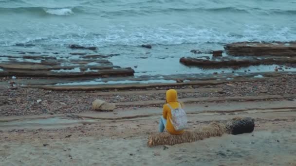 Mujer bonita caminando sola en la playa costera pedregosa cerca del mar, las olas se rompen en la orilla, Egipto Sinaí montaña en el fondo, cámara lenta, 4k — Vídeos de Stock