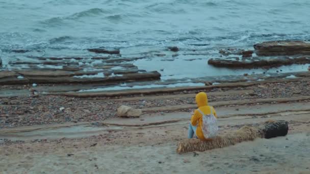 Bella donna che cammina da sola sulla spiaggia rocciosa vicino al mare, le onde si stanno rompendo sulla riva, Egitto Sinai montagna sullo sfondo, rallentatore, 4k — Video Stock