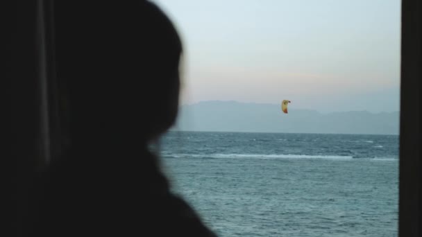 Kobieta pić wino i zobacz, jak ludzie kitesurfing w pięknej czystej wodzie w Dahab Egipt. Zwiedzanie błękitnego morza z górami w tle i ludzie kitesurfing, zwolnione tempo, 4k — Wideo stockowe