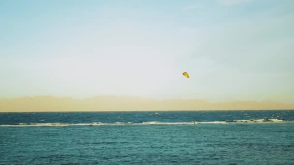 Kite surf em água limpa bonita em Dahab Egito. Explorando a água azul com montanhas no fundo e pessoas windsurf e kite surf, câmera lenta, 4k — Vídeo de Stock