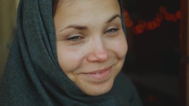 Portret pięknej kobiety z niebieskimi oczami uśmiechniętymi do kamery, kobieta w chustce, zwolniony ruch, 4k — Wideo stockowe