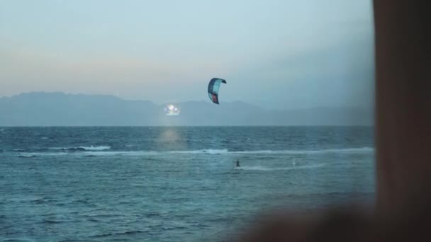 Donna bere vino e guardare come le persone Kite surf in bella acqua limpida in Dahab Egitto. Esplorare il mare blu con le montagne sullo sfondo e la gente kite surf, slow motion, 4k — Video Stock