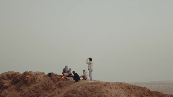 Groep mensen ontspannen op de top van een berg bij zonsondergang, zitten in de buurt van vreugdevuur, genieten van hun tijd - vriendschap, jeugd, slow motion, full hd — Stockvideo