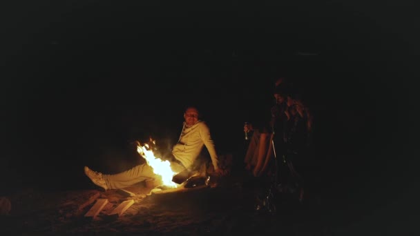 Groupe d'amis s'amuser près du feu de camp sur la plage près de la mer la nuit, vidéo rapide, ralenti, full hd — Video